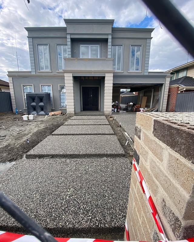Exposed aggregate stepping pads leading up to a new two-storey home