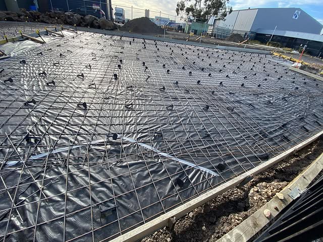 Steel mesh and bar chairs over plastic membrane ready for a slab pour