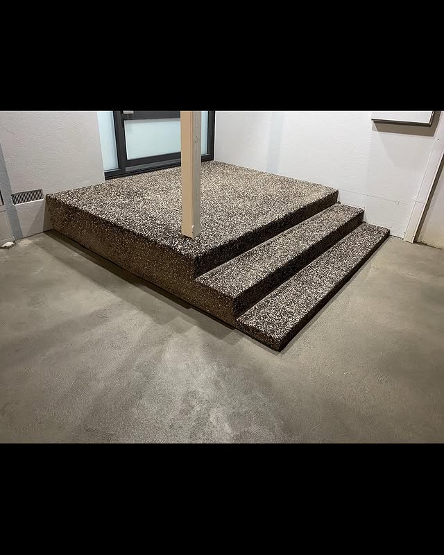 Exposed aggregate steps on a plain concrete floor inside a new home