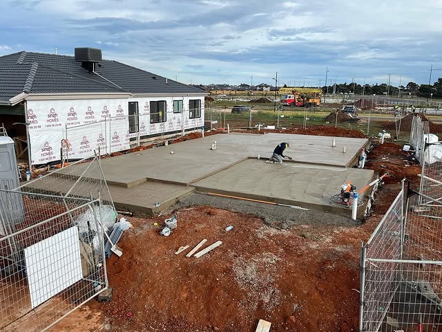 Freshly poured house slab on a new estate behind temporary fencing