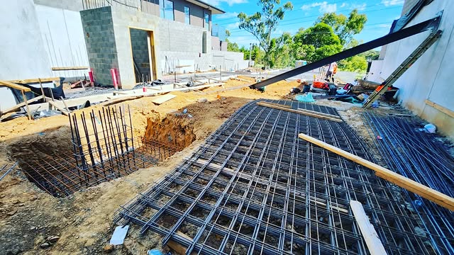 Steel mesh and pier cages set out beside a new block building