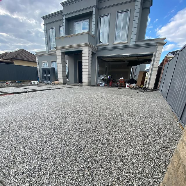 Wide exposed aggregate driveway in front of a new two-storey home