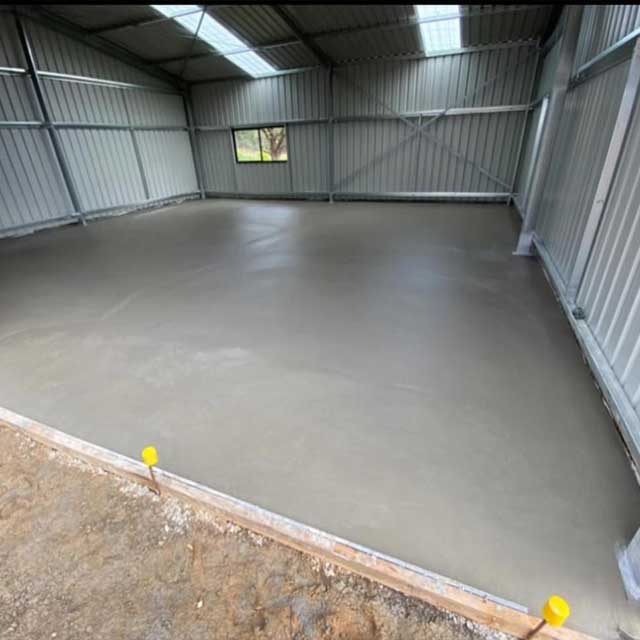 Freshly poured concrete slab inside a steel shed