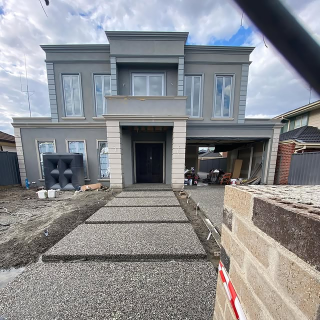 Exposed aggregate stepping pads leading to a new two-storey home