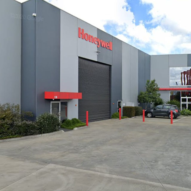 Industrial unit with a roller door, red bollards and a concrete forecourt
