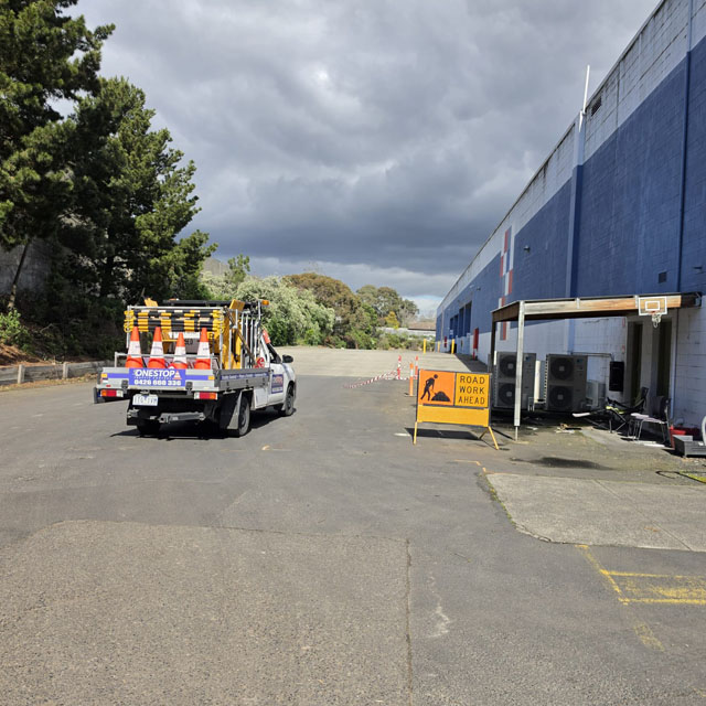Ute loaded with traffic cones parked beside a large blue and white warehouse