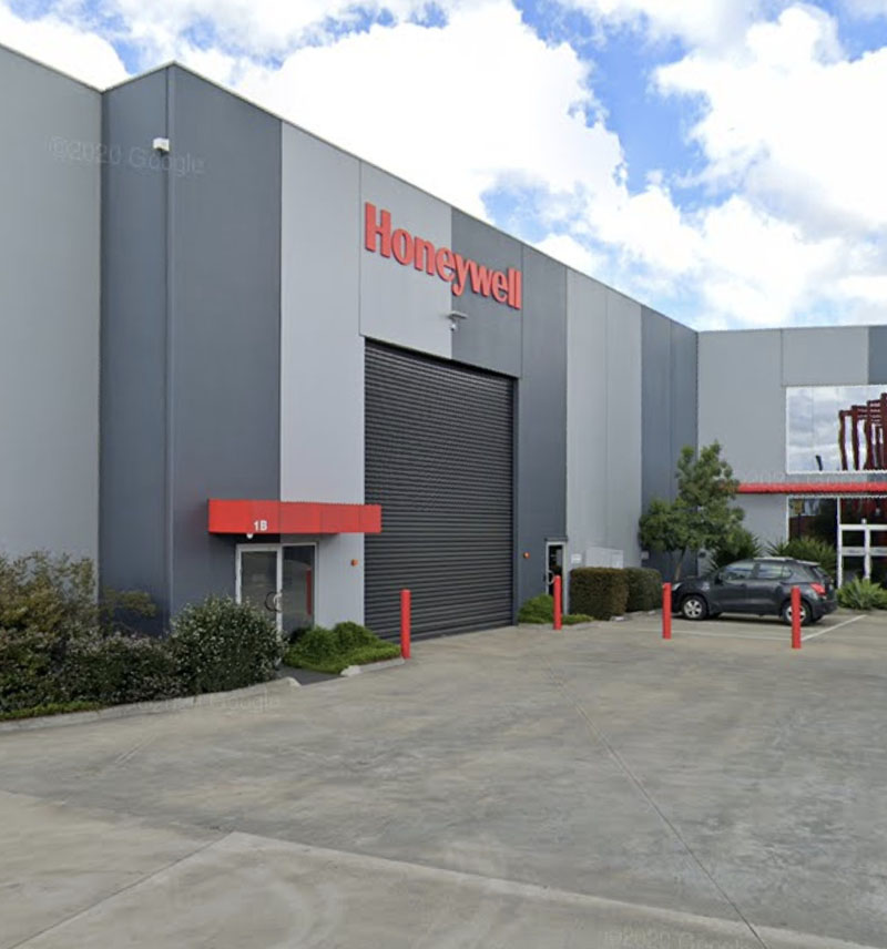 Grey industrial unit with a roller door and a concrete forecourt