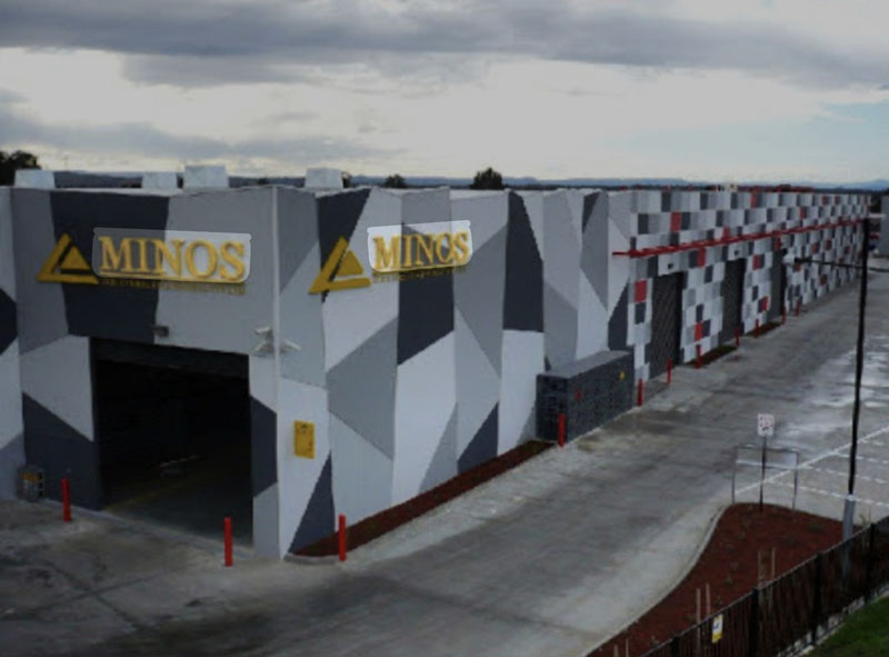 Industrial building with a grey geometric patterned facade and red bollards