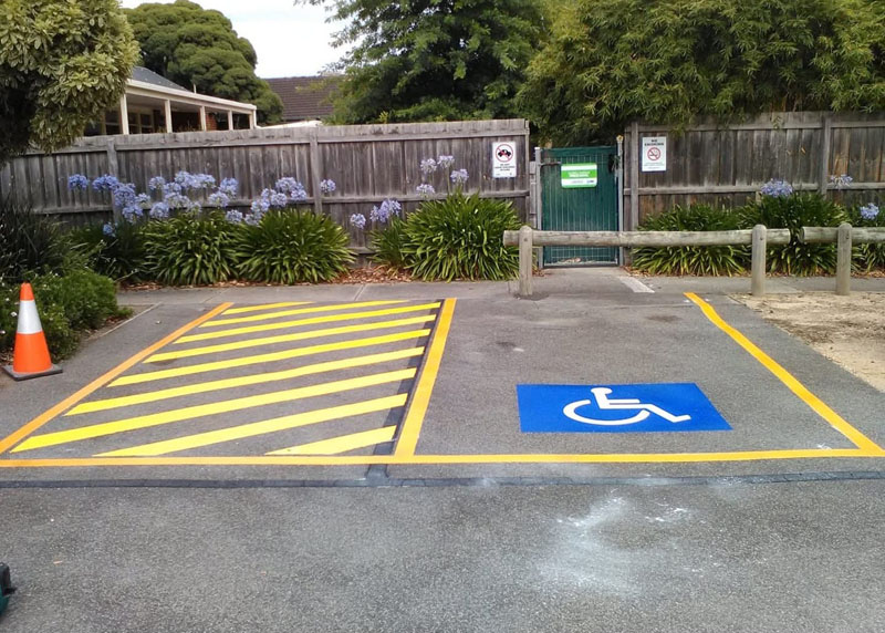 Accessible parking bay with yellow hatching and a blue wheelchair symbol